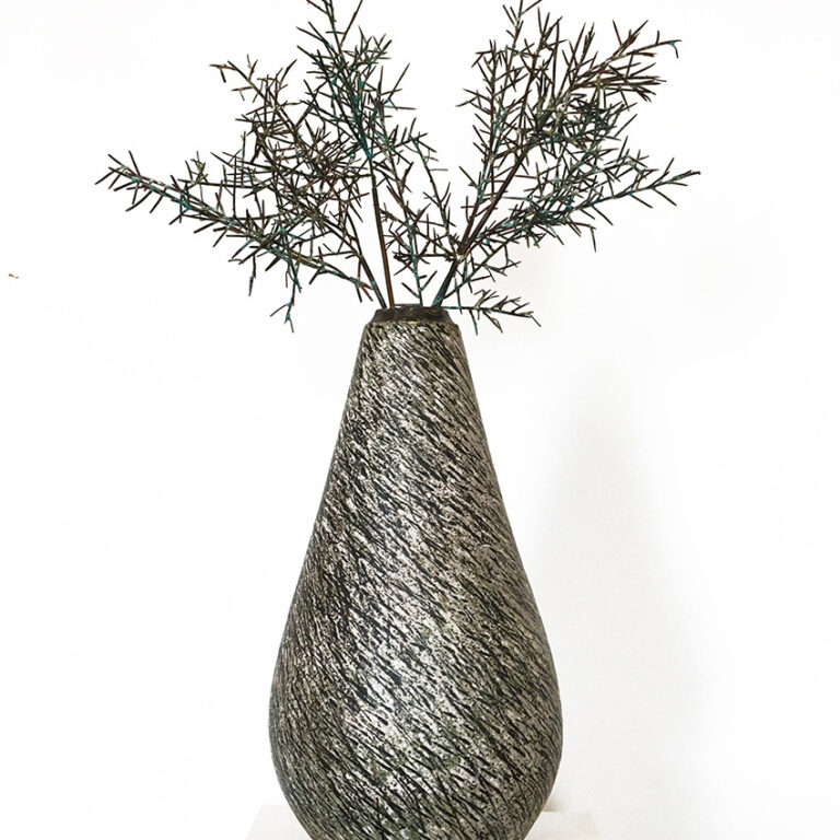 A ceramic vase with spiky metal plants
