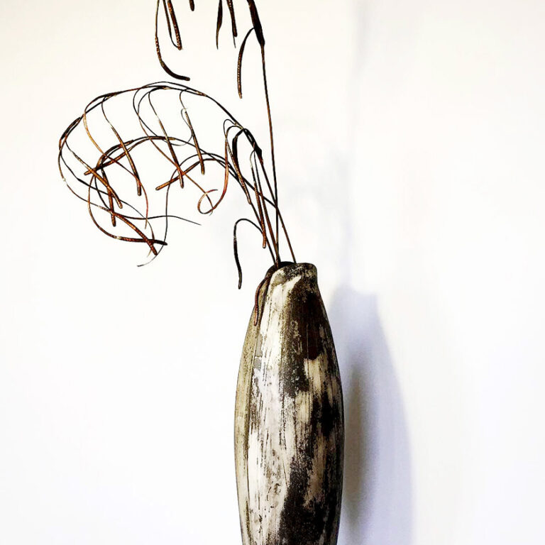 Tall slender ceramic pot with elegant metal fronds